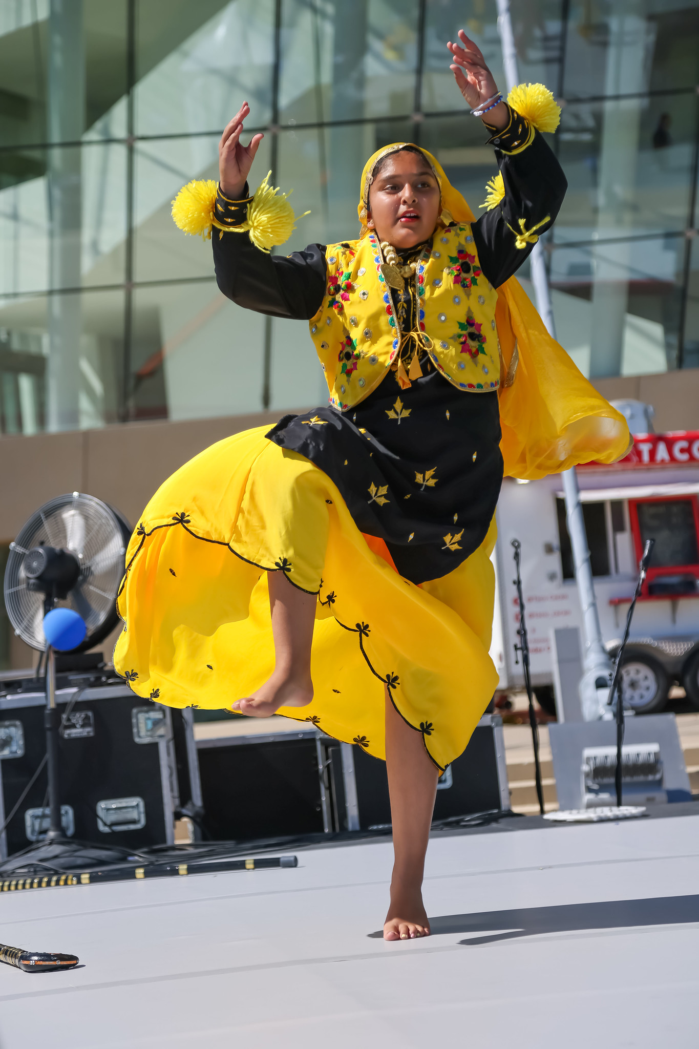 KC Bhangra dancer in yellow at outdoor stage